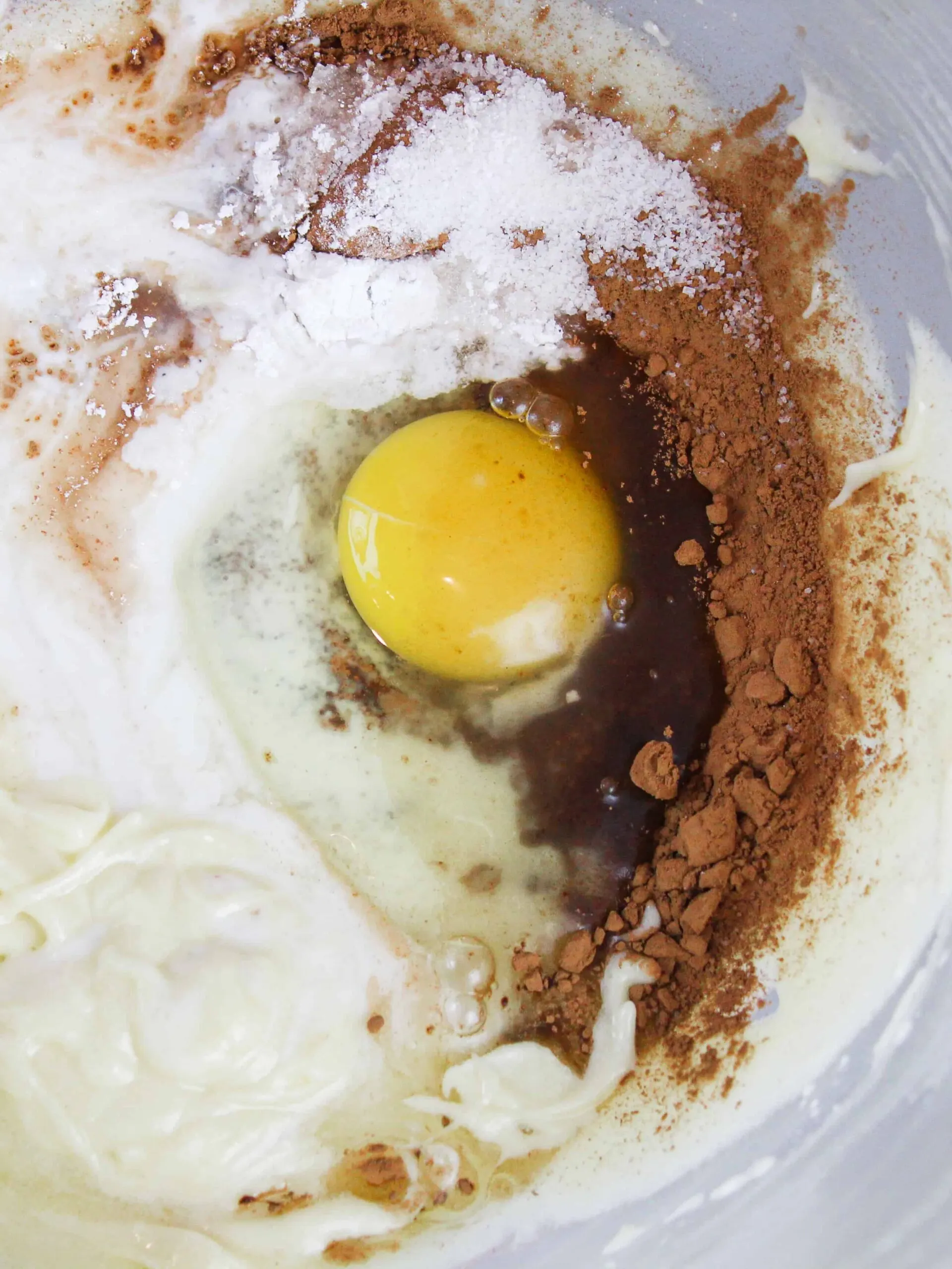 image of vanilla cake batter being turned into chocolate batter

