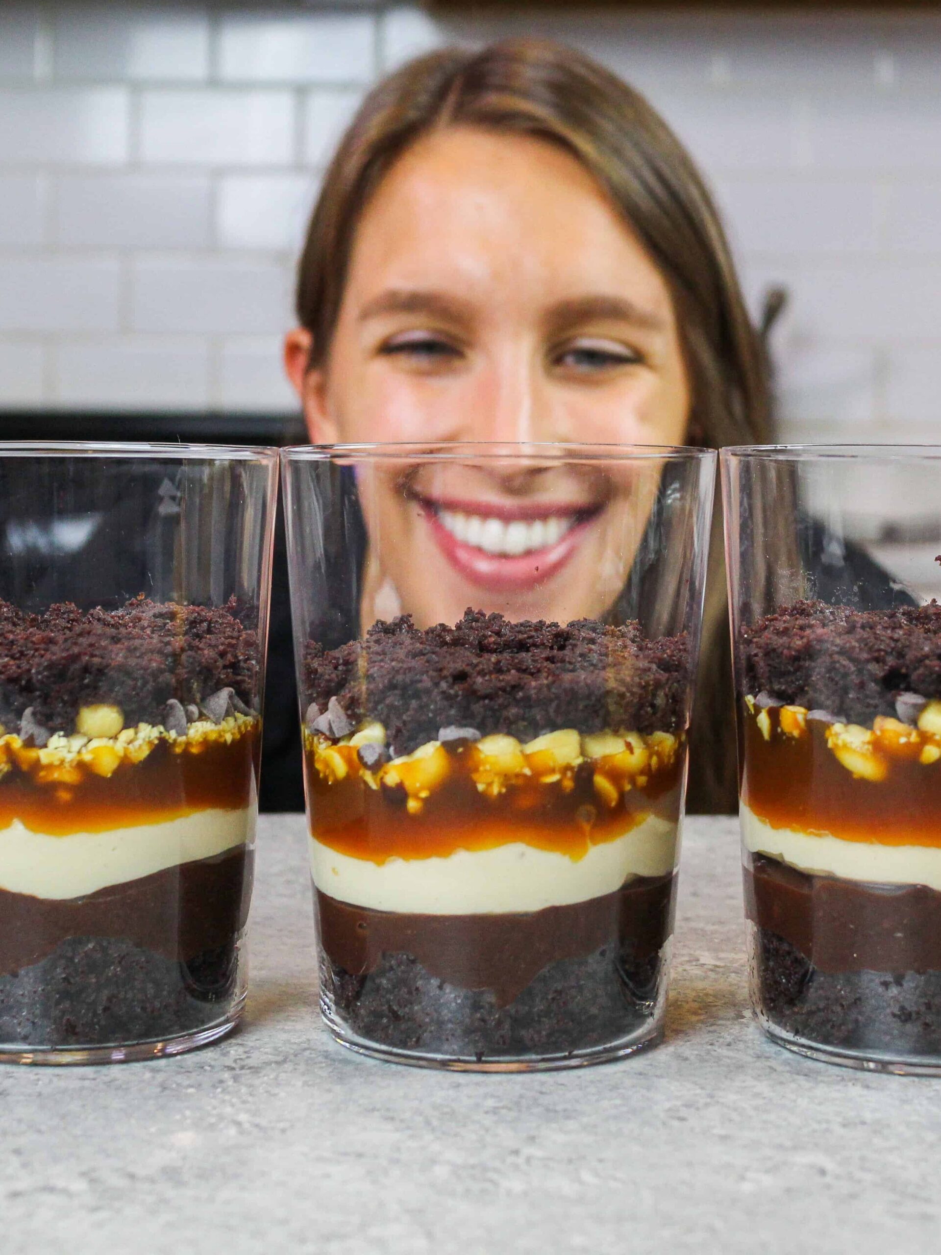 image of chelsey white looking at snickers trifles while making them to make sure the layers are pretty and even