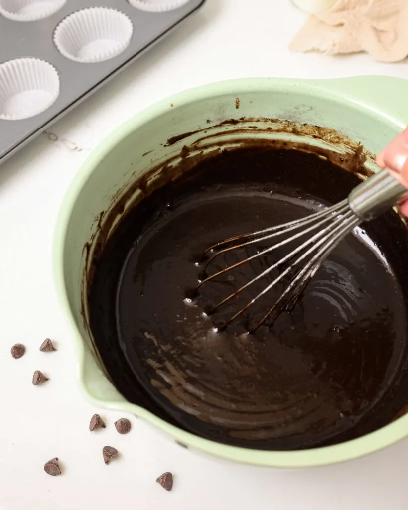 image of black velvet cupcake batter being mixed in a mint green bowl