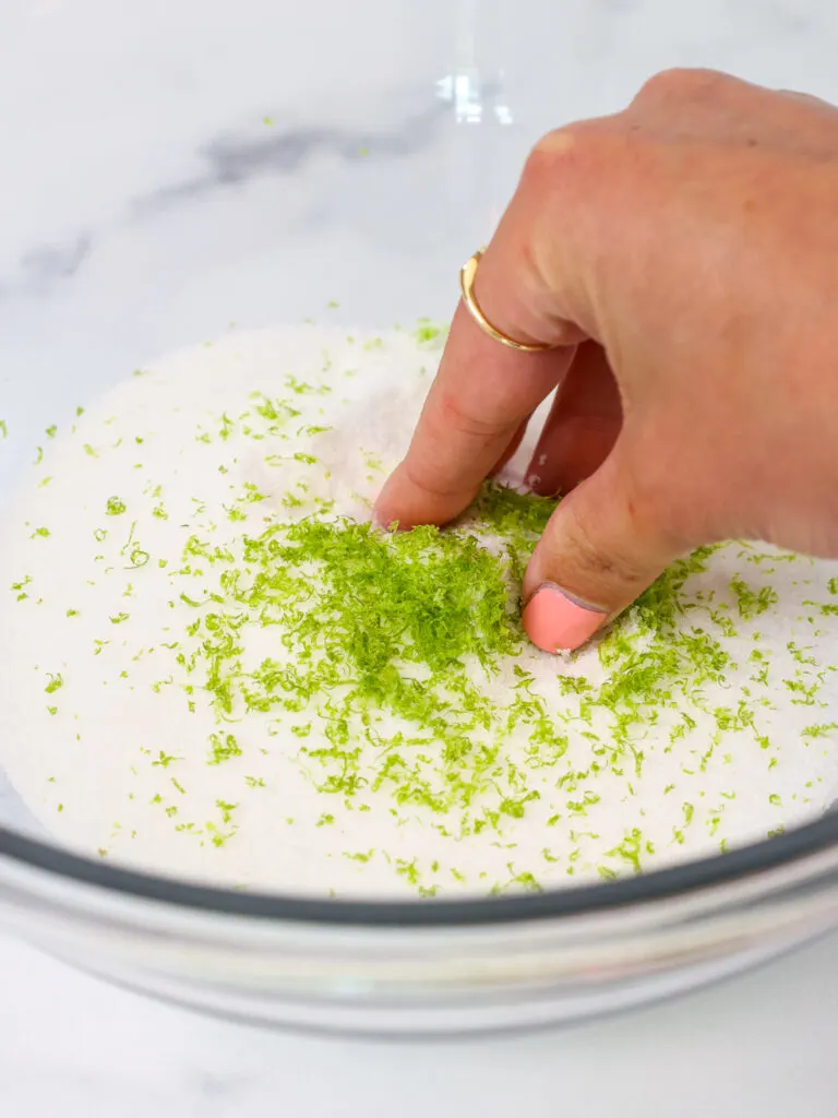 image of lime zest being massaged into sugar to make lime sugar for a batch of lime cupcakes