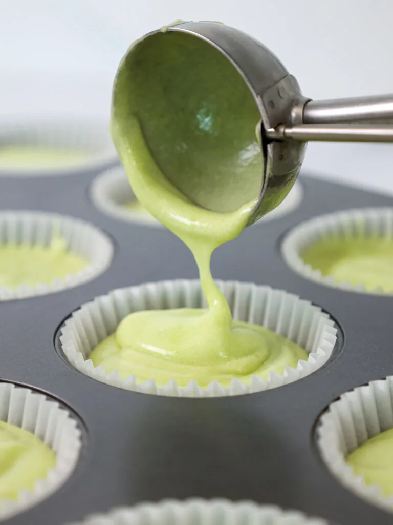 image of lime cupcake batter being scooped into cupcake liners