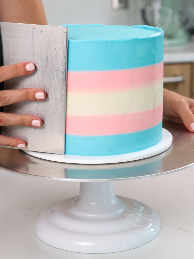 image a cake being frosted with buttercream that looks just like the trans flag