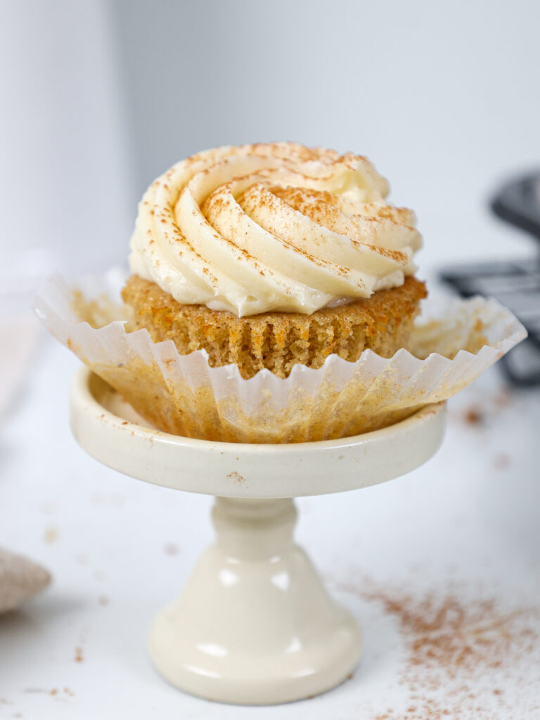 image of a spice cupcake that's been frosted with cream cheese buttercream frosting and unwrapped