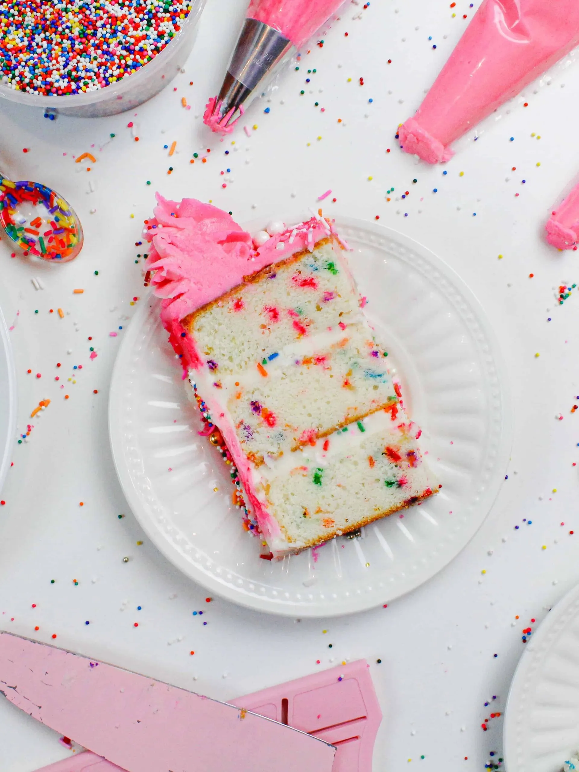 image of small batch funfetti cake slices, placed on small plates surrounded by rainbow sprinkles