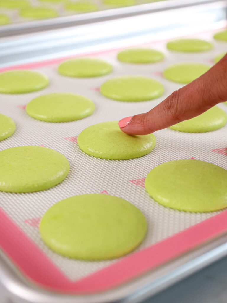 image of green macaron shells that have rested and have become matte and formed a skin