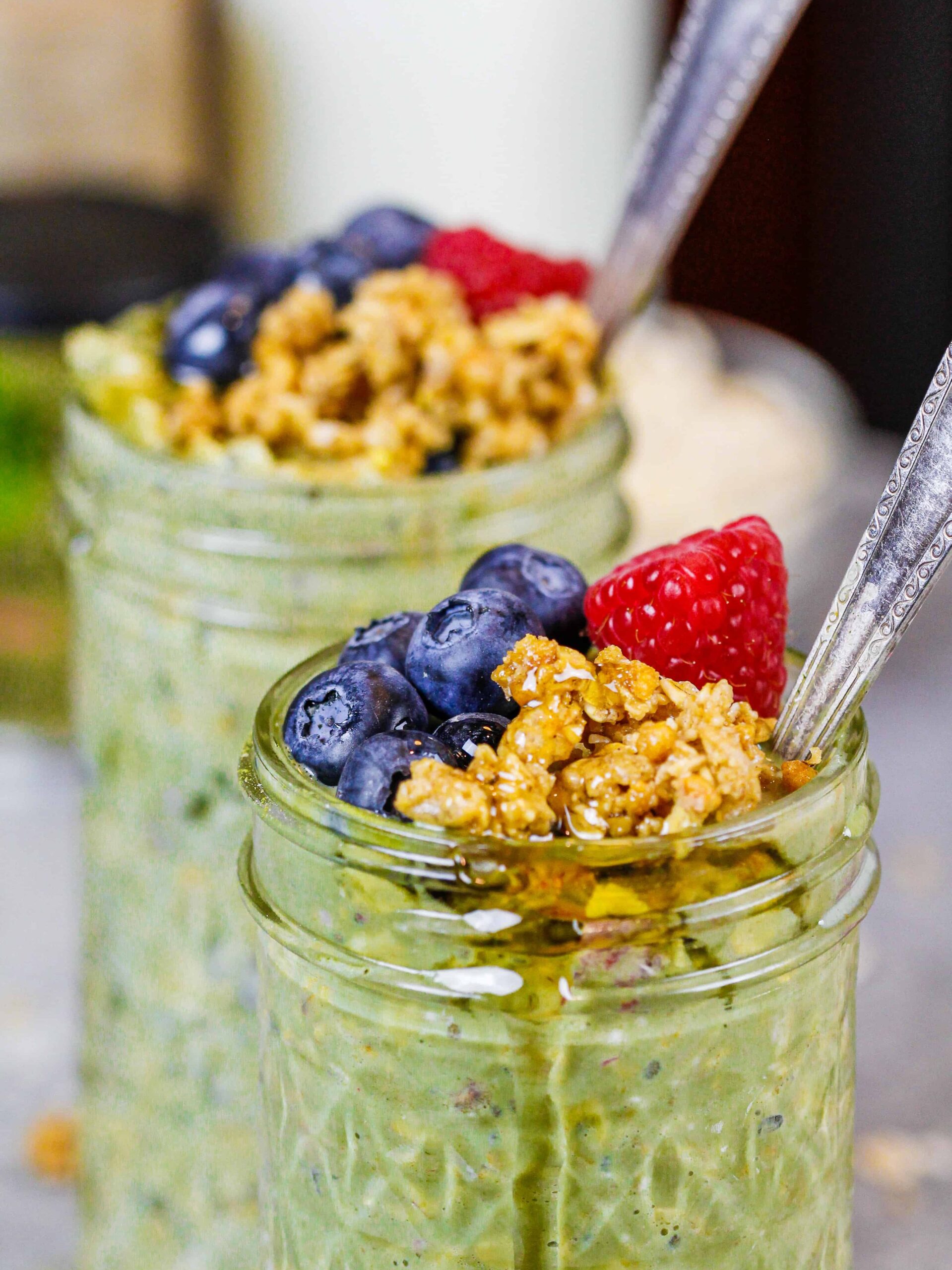 image of matcha oatmeal topped with granola, honey and fresh berries