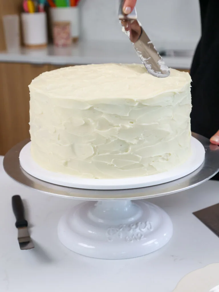 image of a cake being frosted with cream cheese frosting