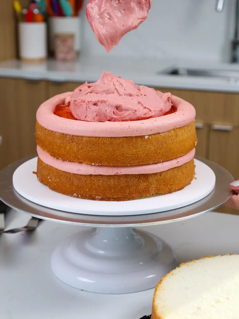 image of a cake being filled with strawberry mousse cake filling