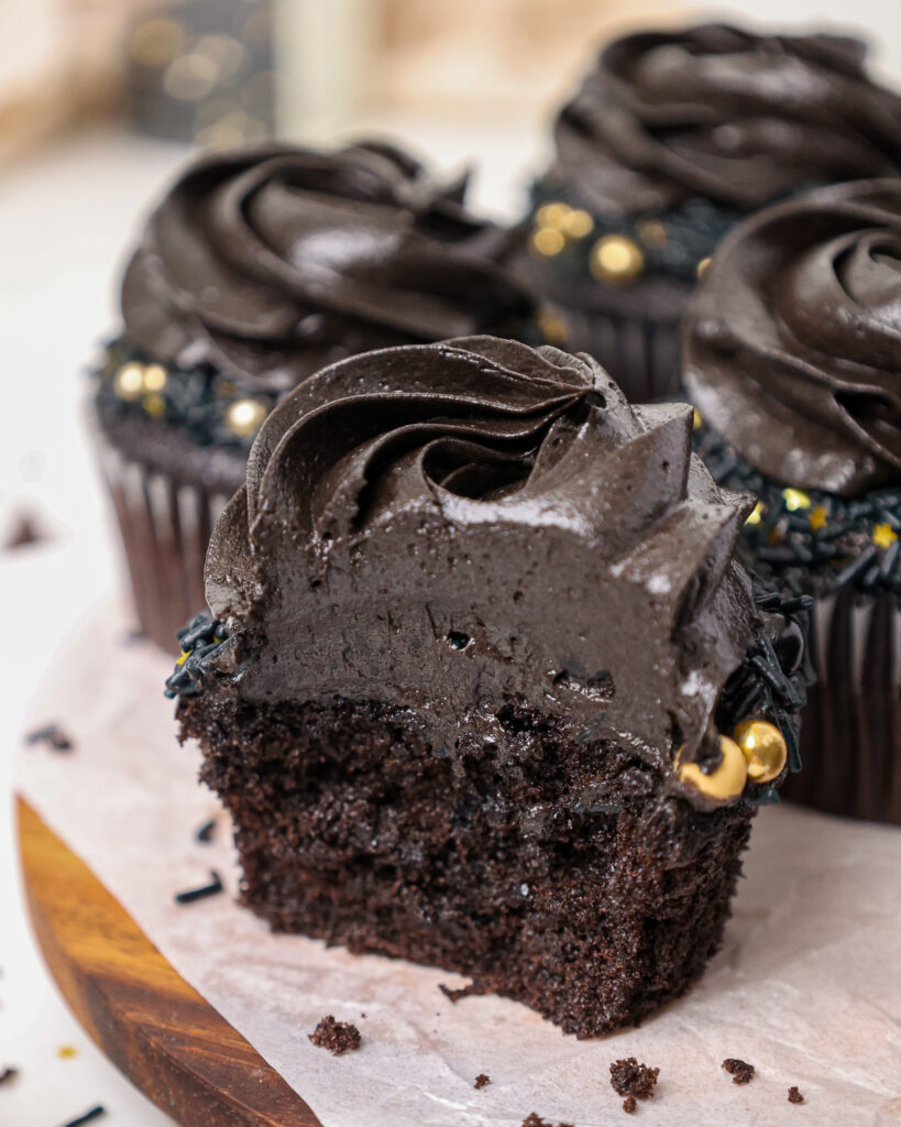 image of a black velvet cupcake that's been bitten into to show how moist and delicious it is