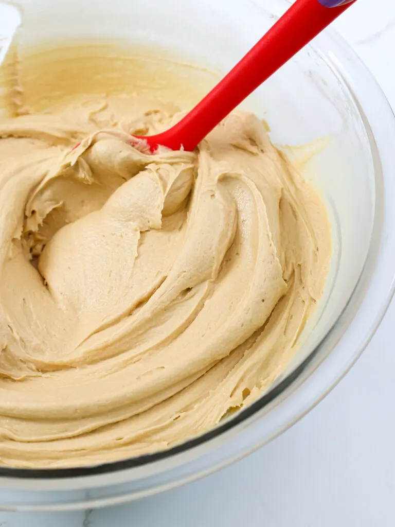image of peanut butter cream cheese frosting that's been mixed with a rubber spatula to give it a super smooth consistency