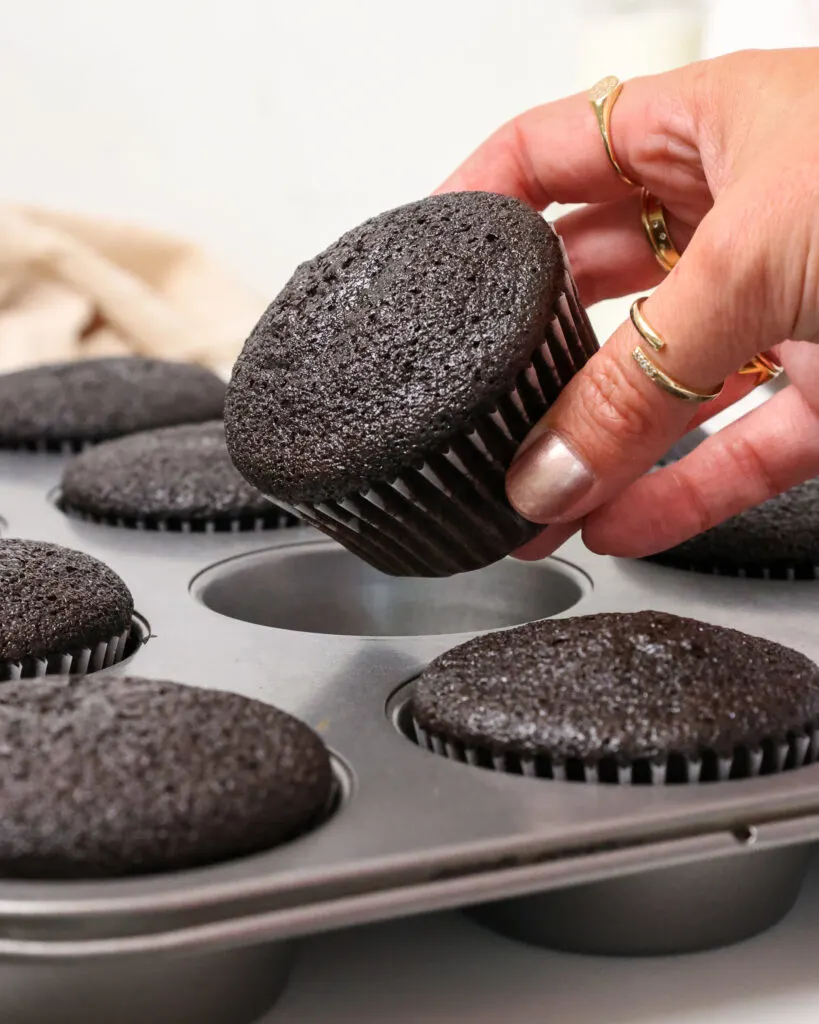 image of a baked black velvet cupcake being held in a hand