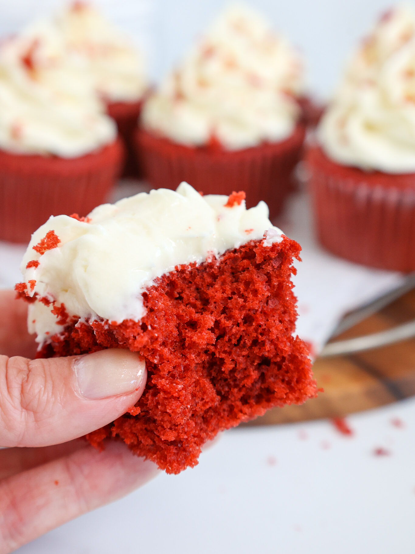 image of a red velvet cupcake that's been cut into to show how tender and soft it is