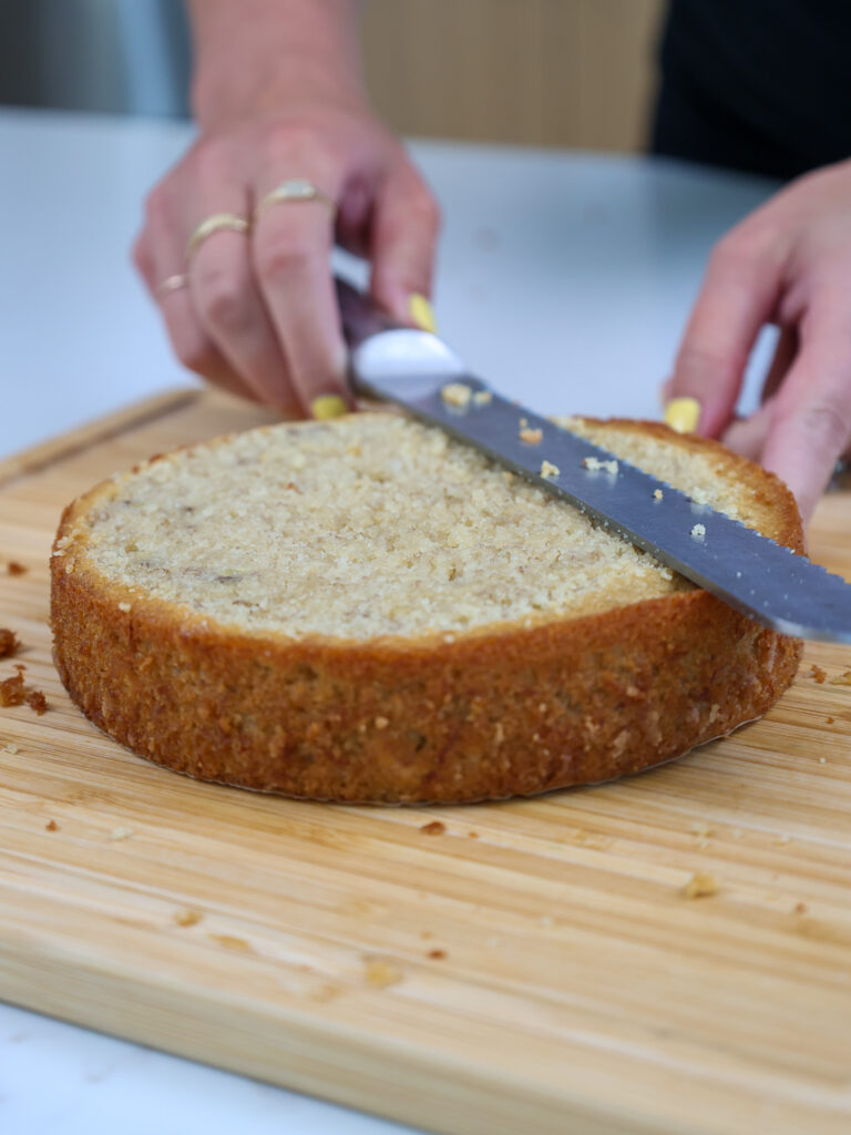image of a 6-inch banana cake layer being leveled with a serrated knife