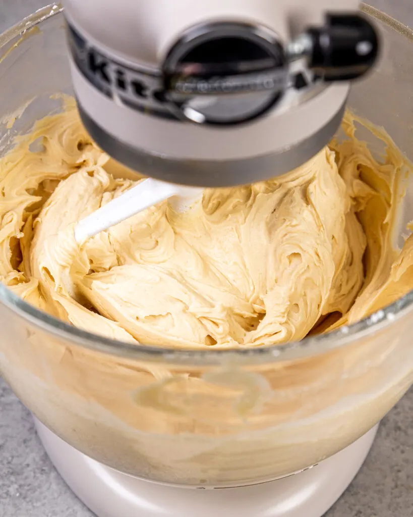 image of peanut butter cream cheese frosting that's being mixed in a KitchenAid mixer with a paddle attachment
