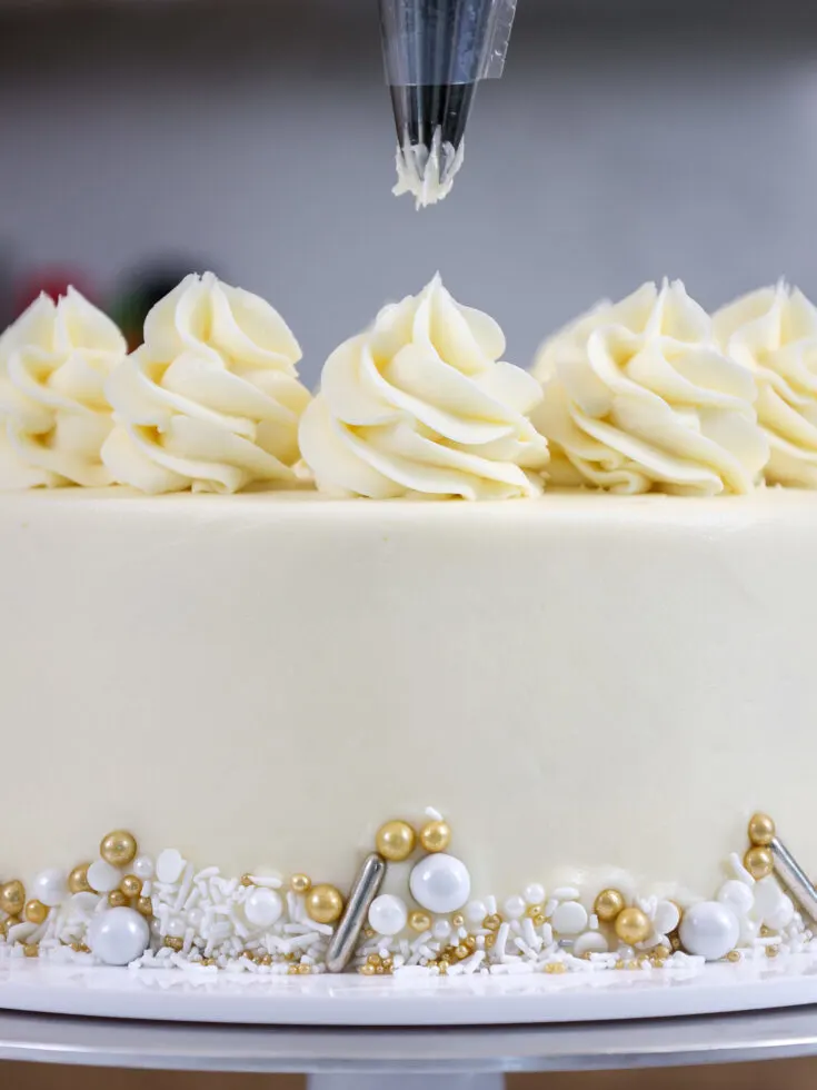 image of almond buttercream being piped on a WASC cake