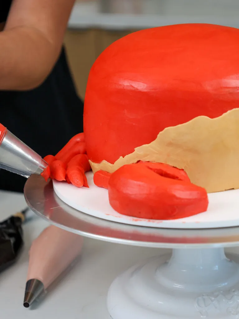 image of frosting legs being piped onto a crab birthday cake
