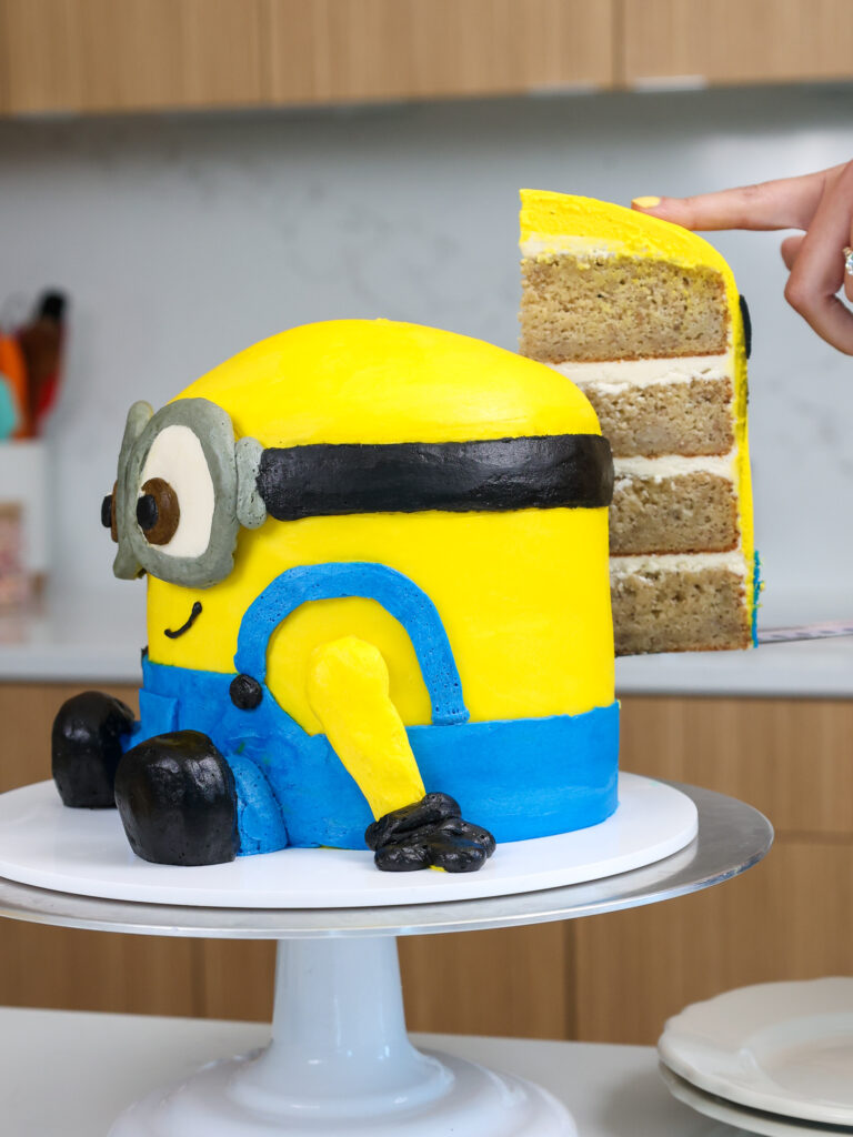 image of a slice of cake being cut from a banana minions cake
