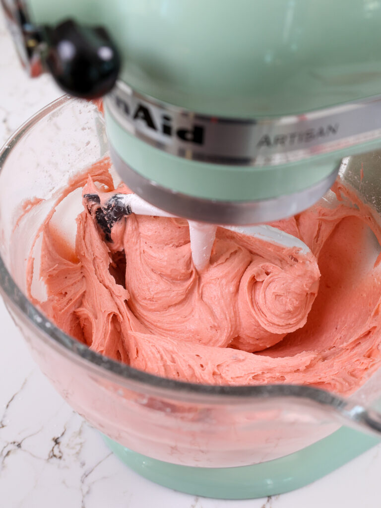 image of strawberry American buttercream being mixed together in a stand mixer
