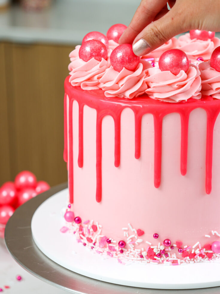 image of pink bubblegum balls being added to a bubblegum cake