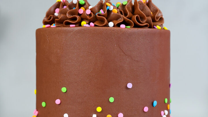 adding sprinkles to top of small chocolate cake
