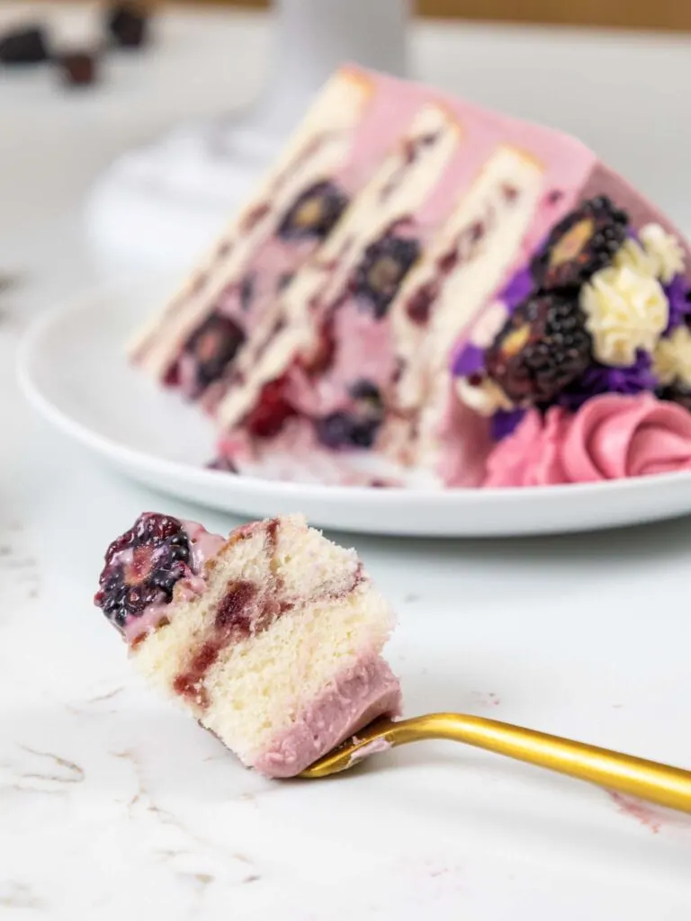 image of a bite of blackberry mousse cake on a fork