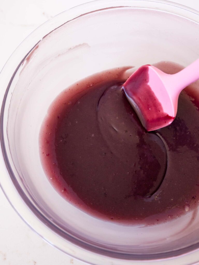 image of white chocolate ganache being mixed together with blackberry jam