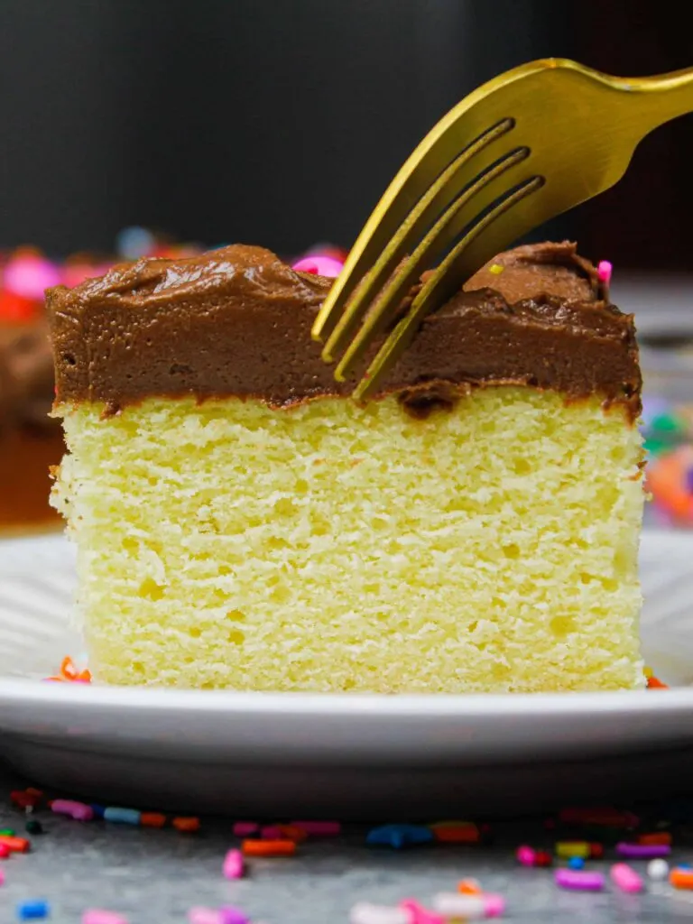 image of a delicious slice of a yellow sheet cake that's been frosted with chocolate buttercream