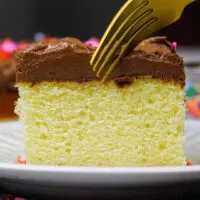 image of a delicious slice of a yellow sheet cake that's been frosted with chocolate buttercream