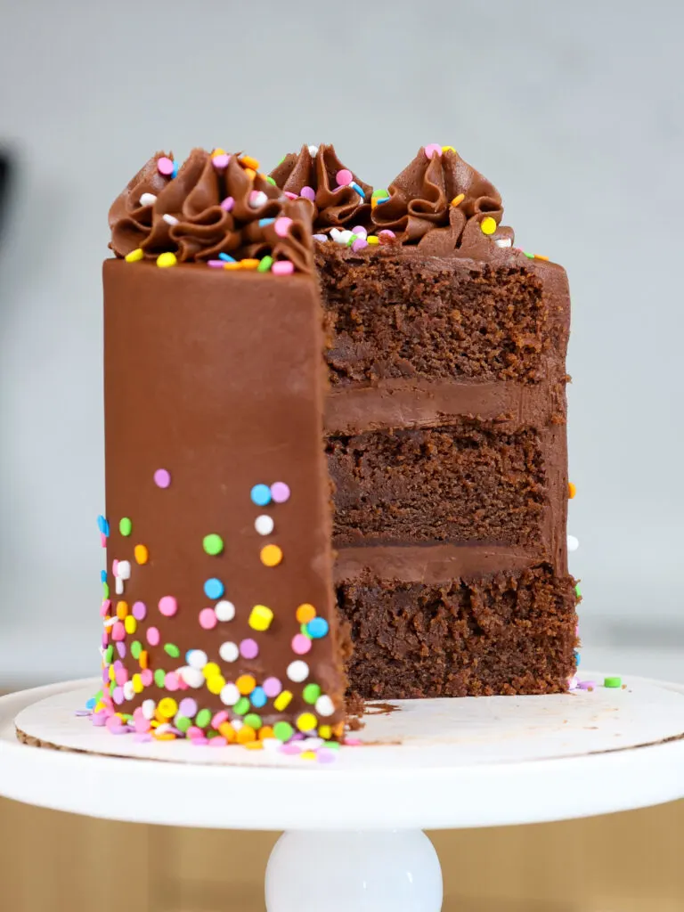 image of a small chocolate smash cake that's been cut into to show its 4-inch cake layers