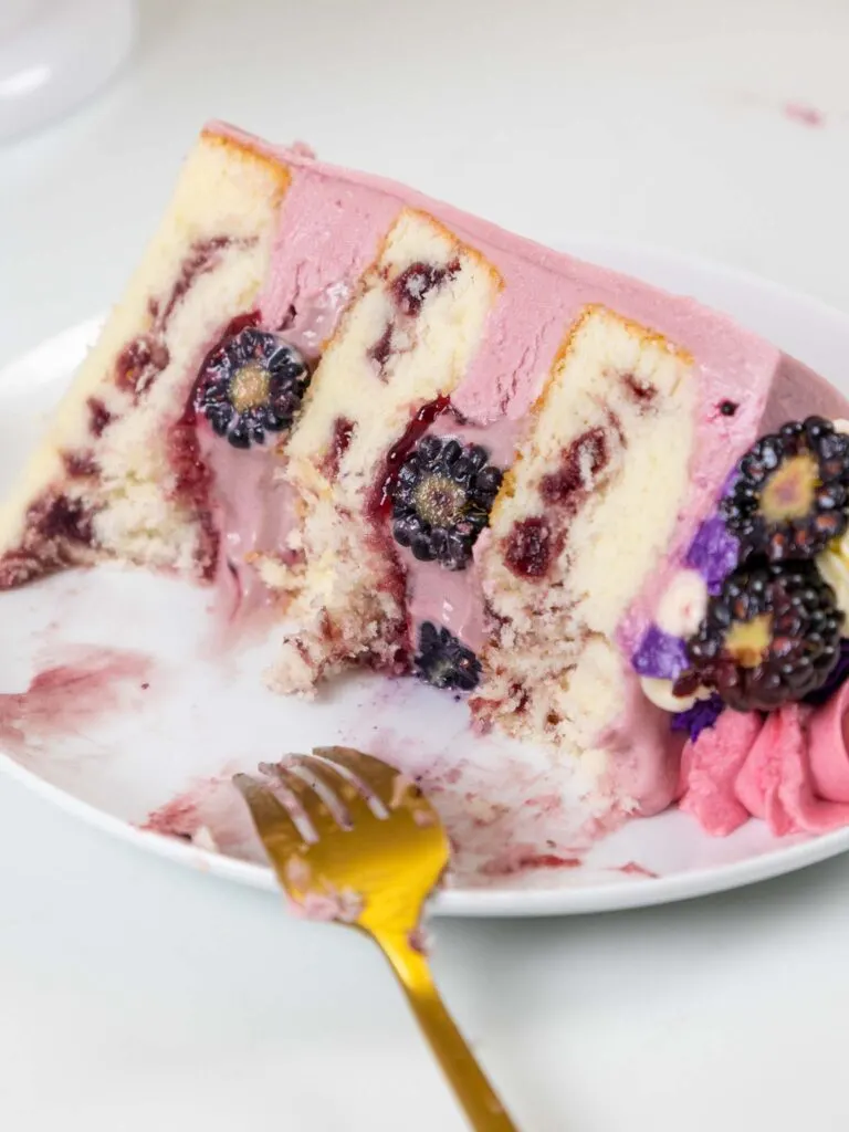 image of a slice of blackberry cake that's been cut into with a fork
