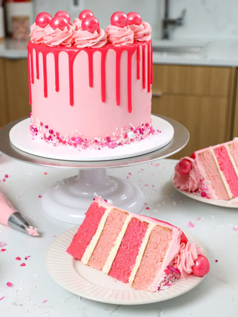 image of a bubblegum cake that's been cut into and a slice has been placed on a cake