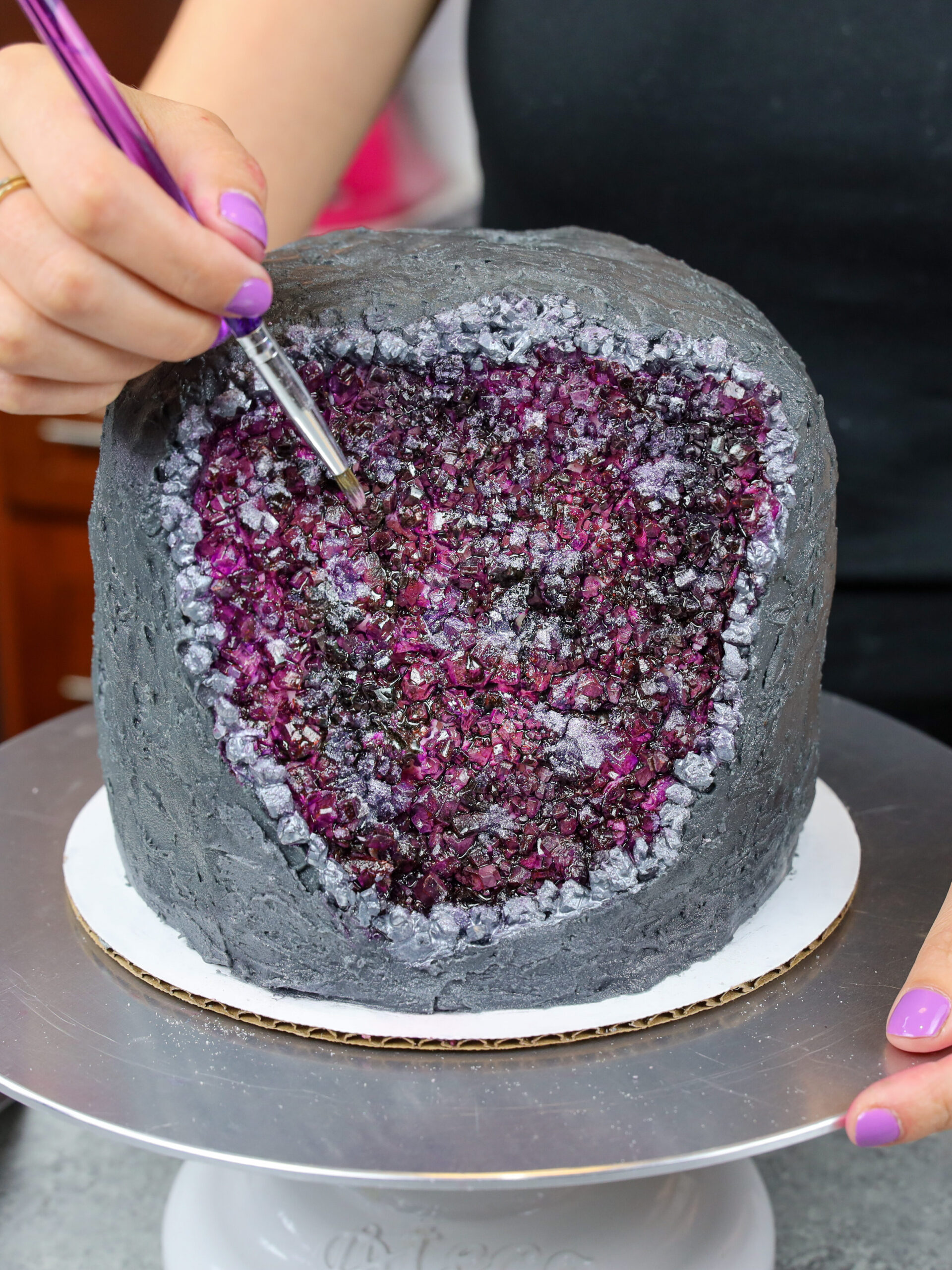 image of a geode cake made with rock candy and edible gel food coloring paint to look like an amethyst