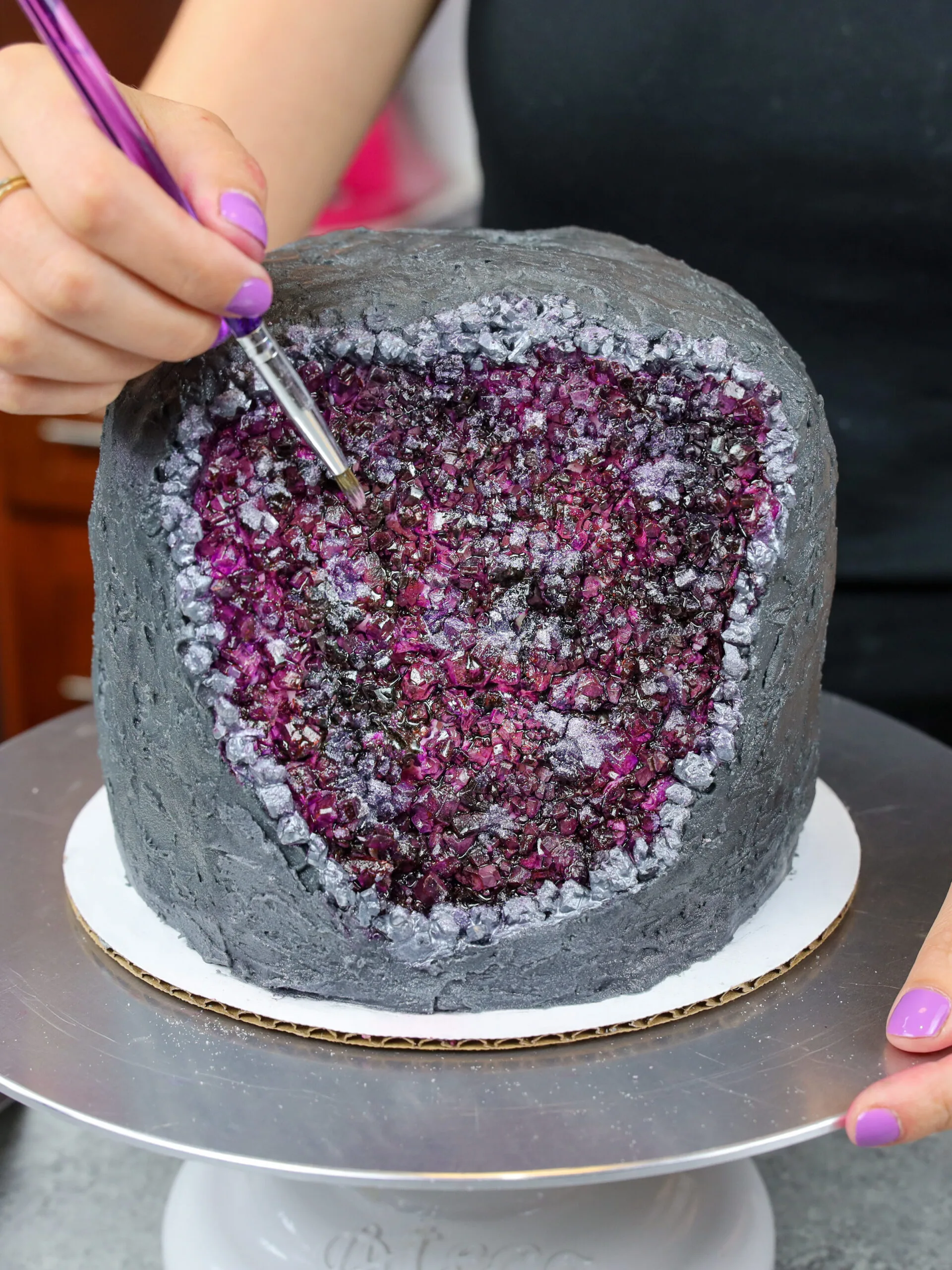 https://chelsweets.com/wp-content/uploads/2022/08/finished-purple-amethyst-cake-finshed-with-paint-brush-edited-scaled.jpg.webp