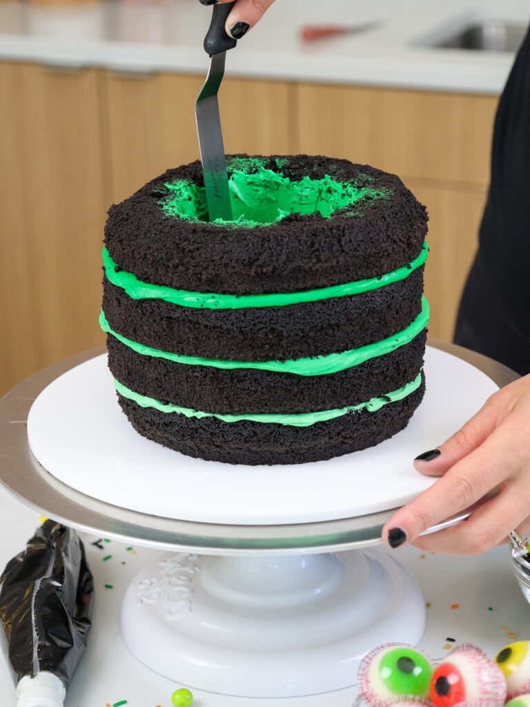 image of the inside cut-out section of a cake being frosted with green buttercream