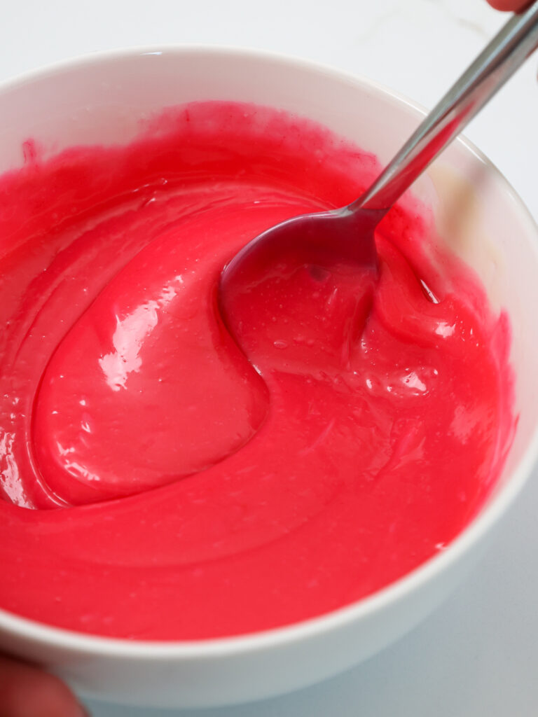 image of hot pink white chocolate ganache being mixed in a bowl