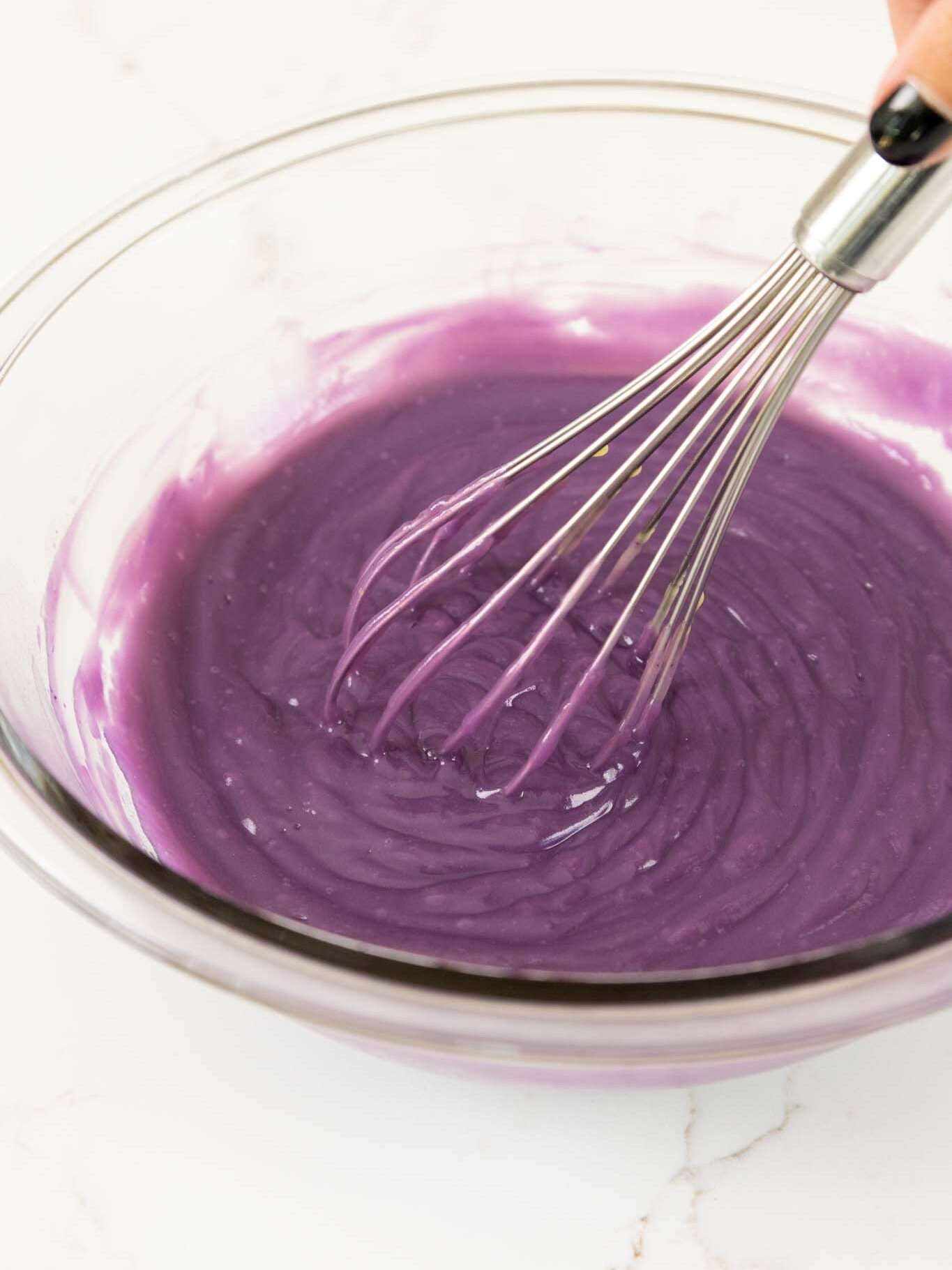 image of purple vanilla pudding being mixed in a glass bowl