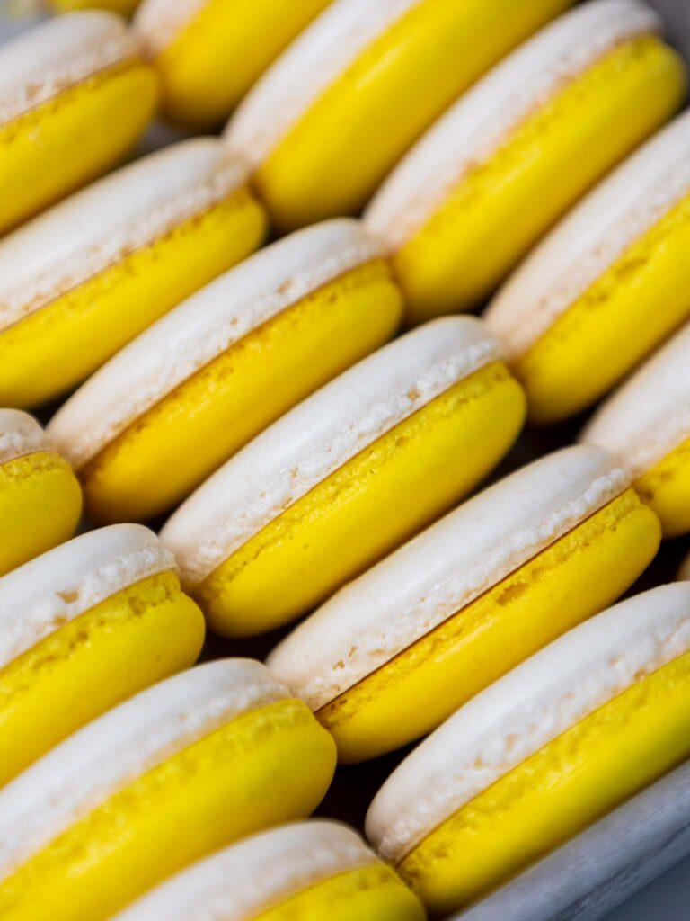 image of yellow and white macaron shells that have been paired together and are ready to be filled