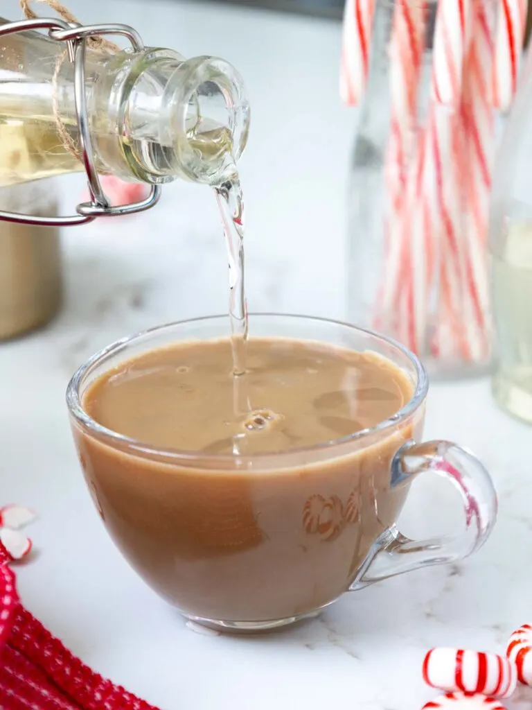 image of peppermint simple syrup being poured into a cup of coffee