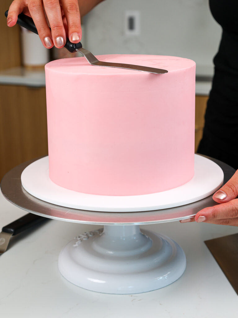 image of a cake being frosted with pink bubblegum buttercream