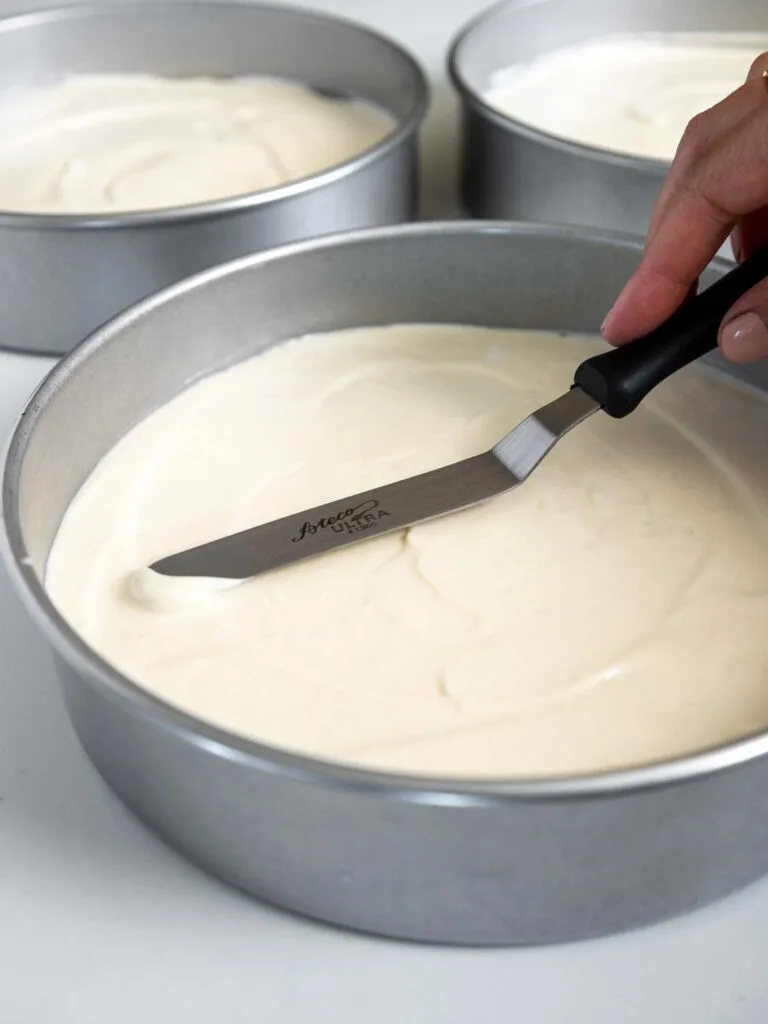 image of vanilla cake batter being smoothed into an 8-inch cake pan