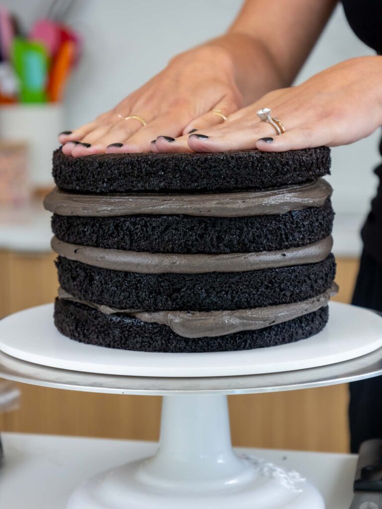 image of black cocoa cake layers being stacked 