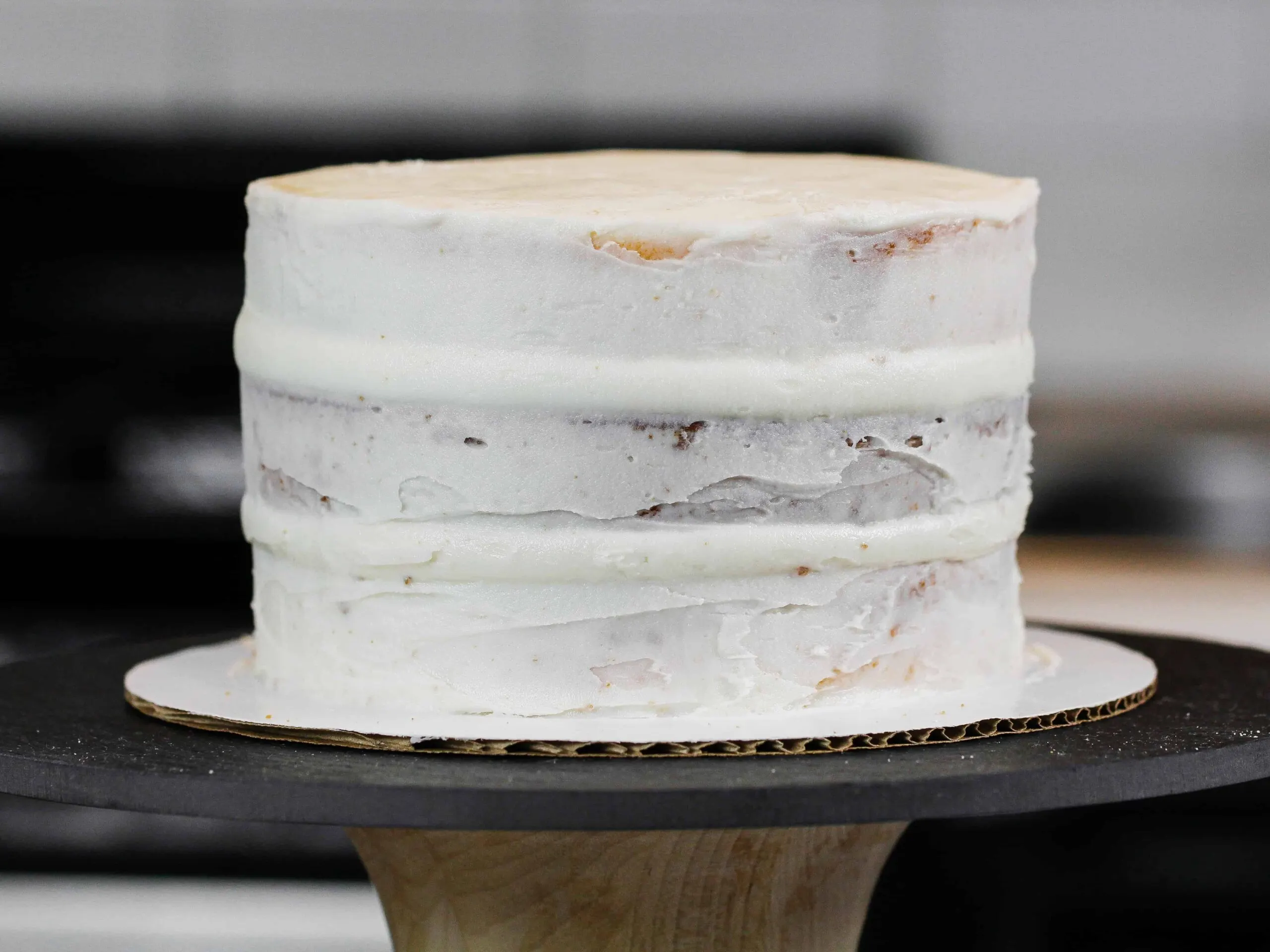 image of a layer cake with bulging sides, because air bubbles were trapped inside the frosting and as the cake settled the air pressed the frosting out.