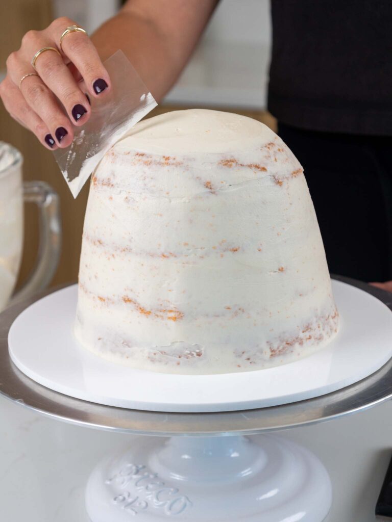 image of a pumpkin cake being crumb coated