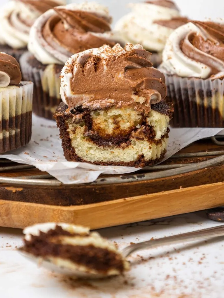 image of a marble cupcake that's been bitten into to show how moist and tender it is