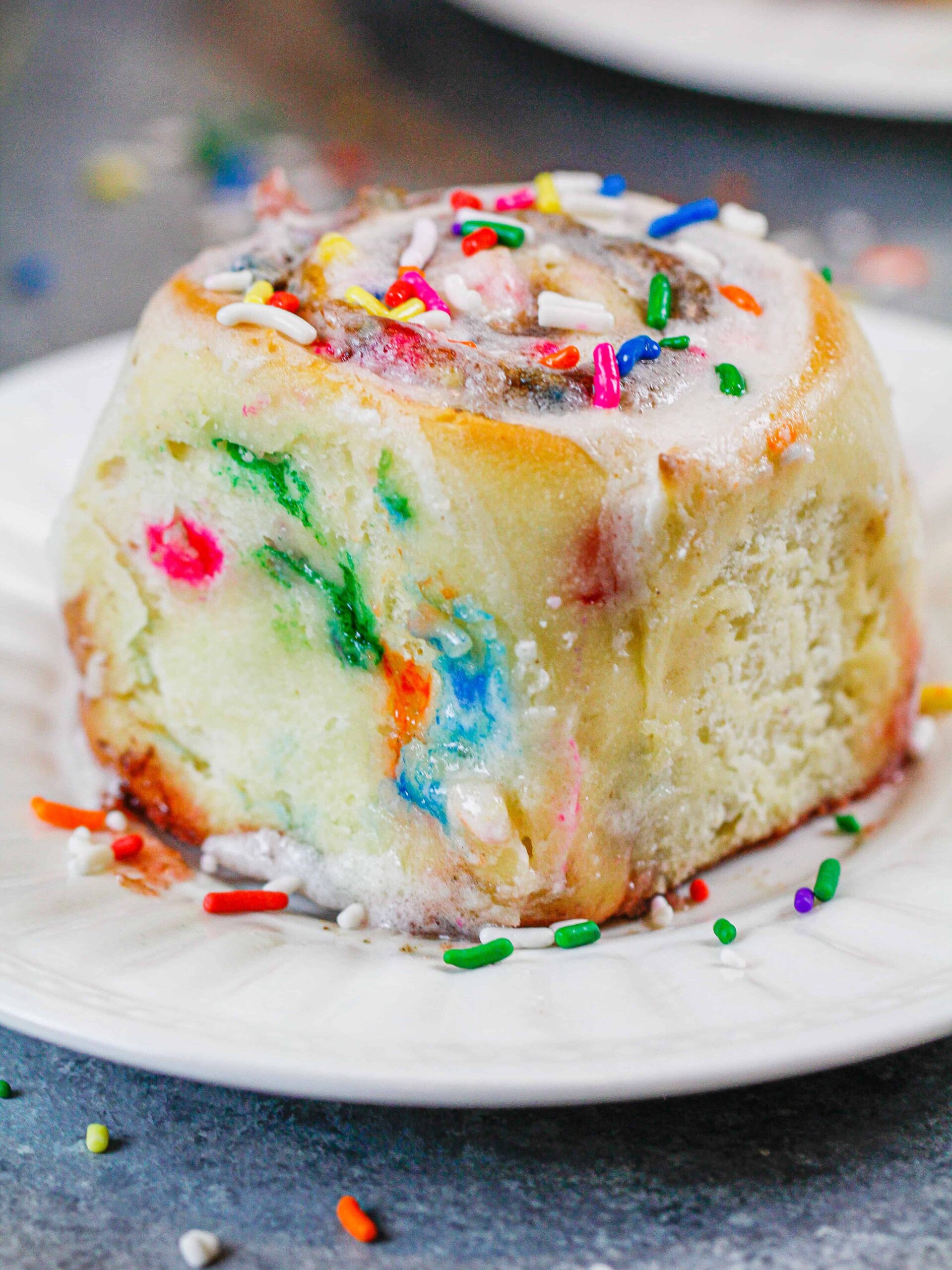 image of baked funfetti cinnamon roll on a plate, ready to be eaten