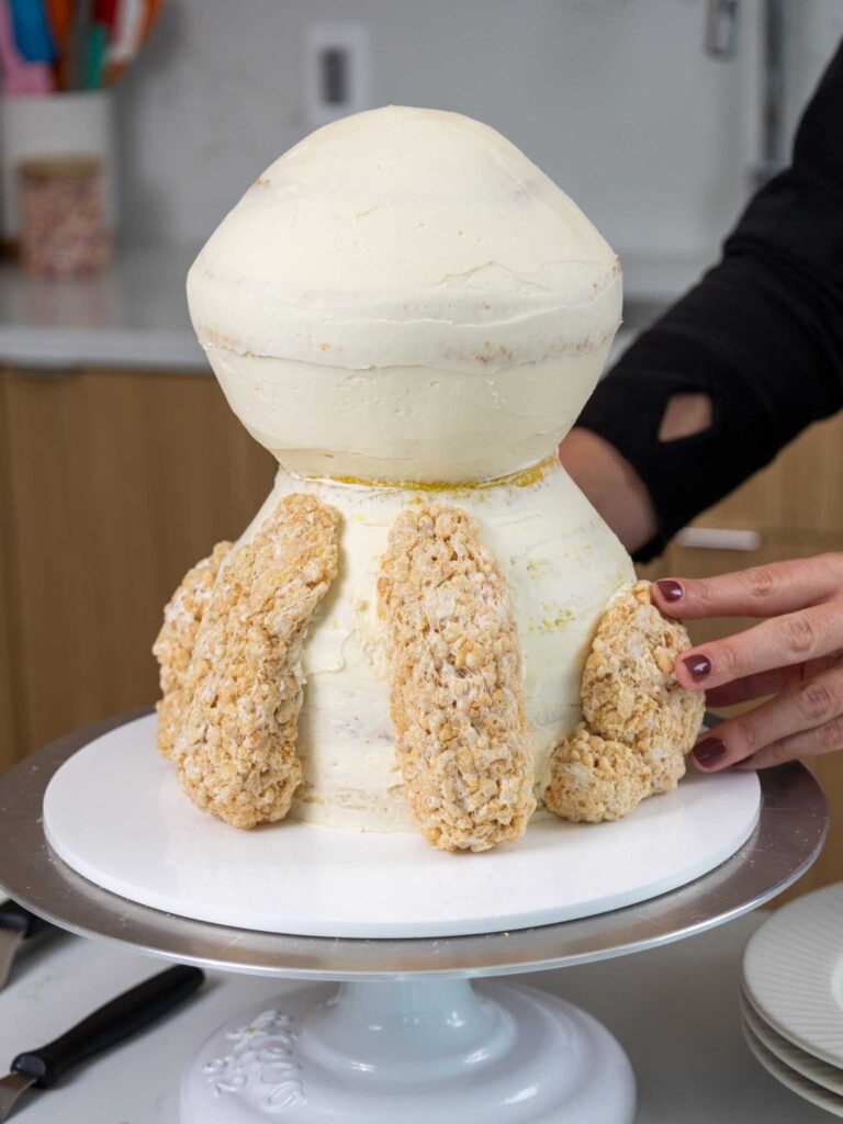 image of rice kripie legs being added onto a lion cake