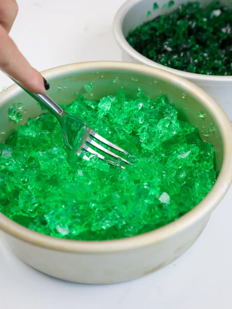 image of green gelatin being crumbled up to be added to a cauldron