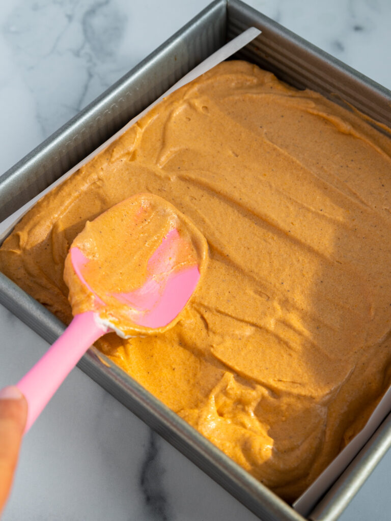 image of no bake pumpkin cheesecake batter being smoothed into a pan