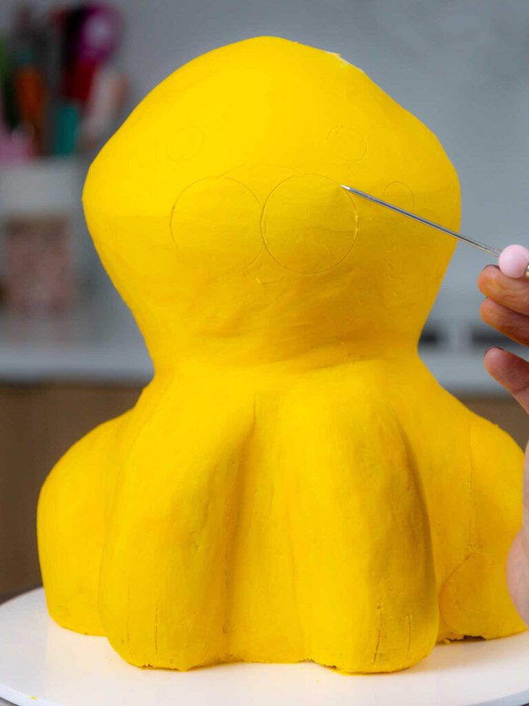 image of a face being traced onto a cake using a scribe