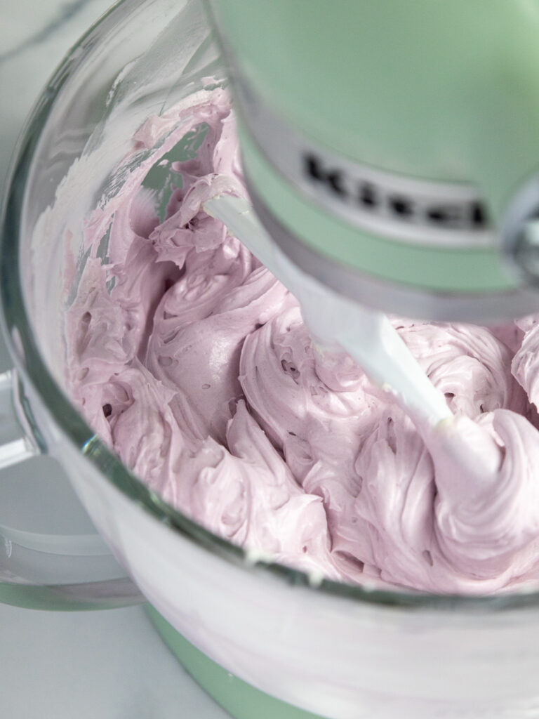 image of lavender Swiss meringue buttercream being mixed in a KitchenAid mixer